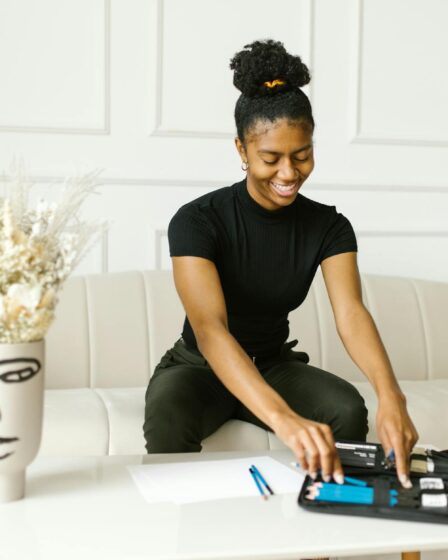 woman sitting on a sofa putting pencils on a case