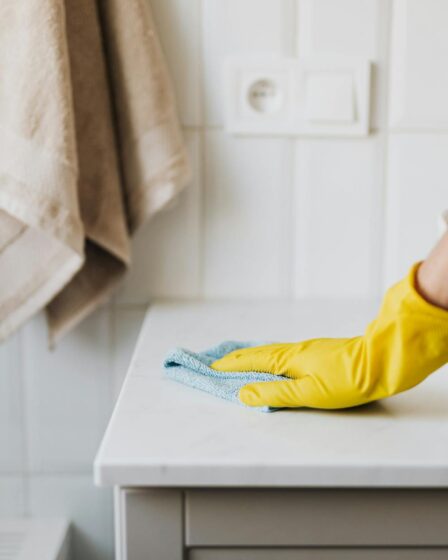 crop housewife cleaning surface near sink