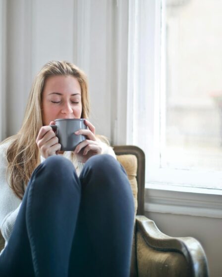 woman holding gray ceramic mug