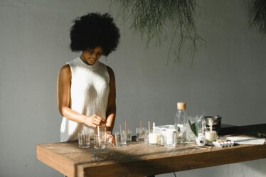 cheerful black woman making candles