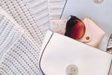 trendy handbag with sunglasses on knitwear