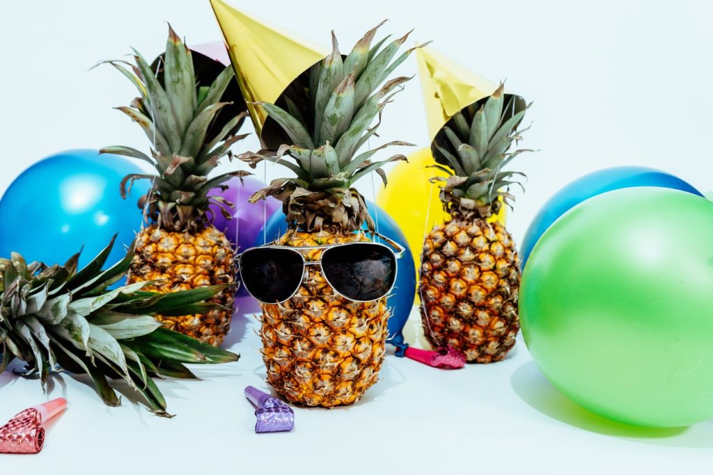 Decoração de festa com abacaxis, balões e chapéus