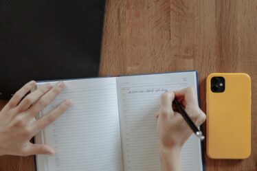 person writing on notebook