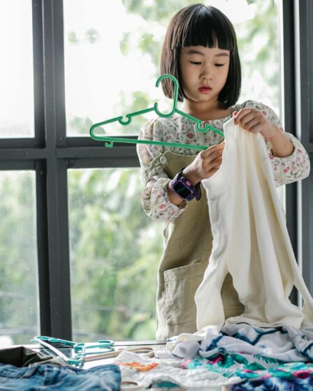 little girl doing housework in room