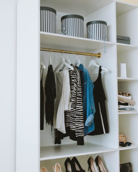 clothes hanged on white wooden cabinet