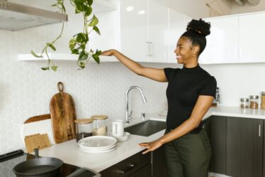 a smiling young woman organizing her kitchen
