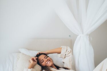 a smiling woman lying on the bed