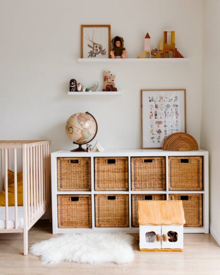 interior of children bedroom with wooden furniture and toys and globe placed on shelves in room