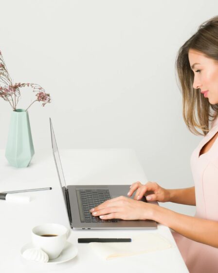 woman in pink dress using laptop computer