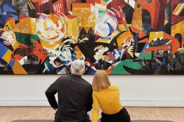 people looking at painting in art gallery