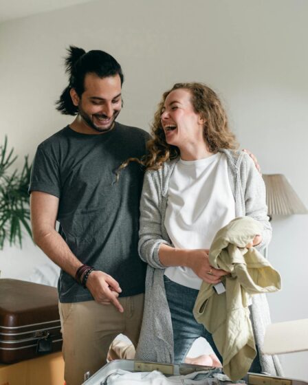 excited couple unpacking boxes in new apartment