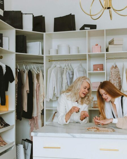 woman in white and girl with ginger hair looking at the jewelry on drawer in the wardrobe