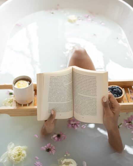 woman reading book in bathtub during spa procedures
