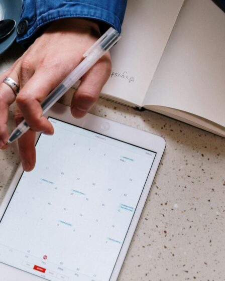 person holding pen and using a tablet