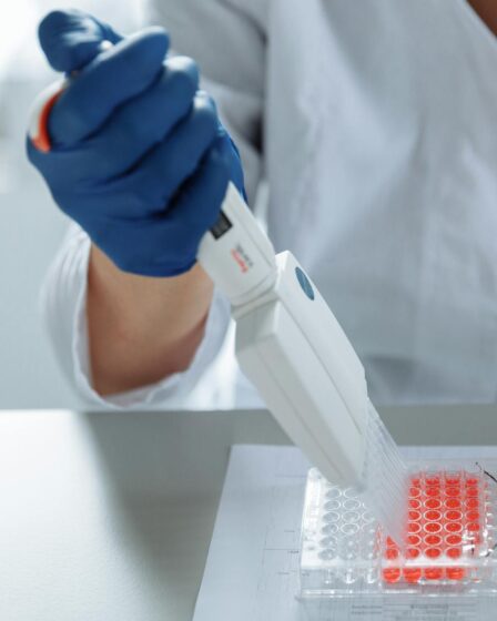 close up of a lab worker distributing medication into capsules